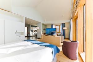 a bedroom with a large bed and a television at Upstalsboom Family Suiten und Lofts in Wyk auf Föhr +47 photos