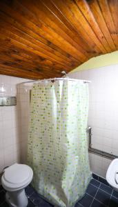 y baño con aseo y cortina de ducha. en KM SUN HOSTEL en San Carlos de Bariloche