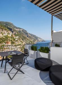 a balcony with a table and chairs and the ocean at Hotel Villa Franca in Positano +137 photos