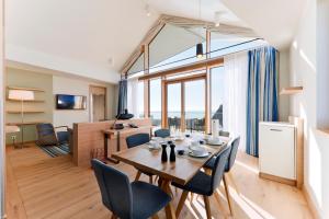 a dining room and living room with a table and chairs at Upstalsboom Family Suiten und Lofts in Wyk auf Föhr