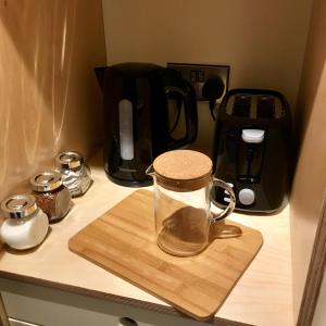 a glass jug on a wooden cutting board on a counter at Black Knowe, Luxury Glamping Pods, Ballycastle in Ballycastle