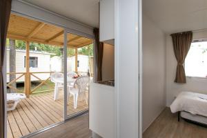 a small house with a kitchen and a deck at Camping Klaus in Cavallino-Treporti