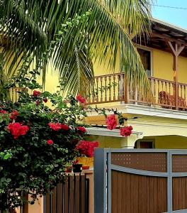 ein Haus mit einem Zaun und einem Balkon mit roten Blumen in der Unterkunft Casa Accacias in Port Louis