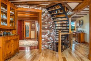 a living room with a brick wall and a staircase at THE MANSION on 5 Acres Overlooking Sunday River in Newry