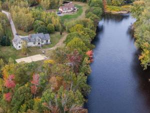 uma vista aérea de uma casa ao lado de um rio em The PADDLEHOUSE All-Season Bethel Maine Rental em West Bethel