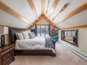 um quarto com uma cama e uma grande janela em The PADDLEHOUSE All-Season Bethel Maine Rental em West Bethel
