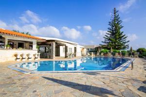 a swimming pool in front of a house at Villa Mare Monte ApartHotel in Malia