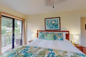 Un dormitorio con una cama y una ventana grande. en Hanalei Bay Villas #33, en Princeville