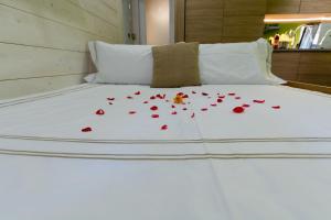 a white bed with red roses on it at Nido d'amore nel cuore di Limone in Limone Piemonte