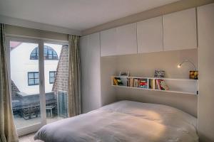 ein Schlafzimmer mit einem Bett und einem großen Fenster in der Unterkunft Zoutezoute in Knokke-Heist