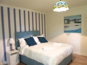 a bedroom with a bed with blue and white pillows at Abbots Leigh B&B in Glastonbury