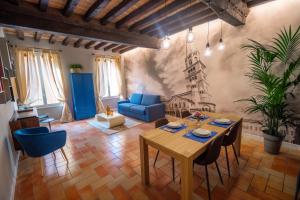 uma sala de estar com uma mesa e um sofá azul em Old Town - Boutique Rooms em Módena