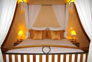 Cette chambre comprend un grand lit et 2 lampes. dans l'établissement B&B Le Clos des Raisins, à Beblenheim