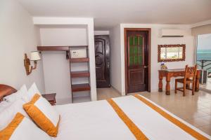 a bedroom with a bed and a desk and a table at Sol Caribe Sea Flower in San Andrés