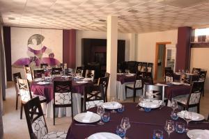 a dining room with tables and chairs with purple table settings at Hotel Rural Casa Ramiro in Cedrillas