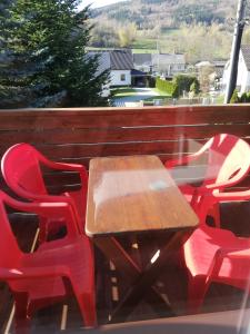 a wooden table and red chairs on a balcony at Apartmany Agatha in Loučná nad Desnou