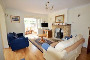 a living room with a couch and a fireplace at Woodside Cottage in Godshill