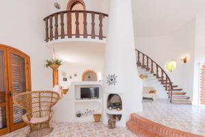 a living room with a staircase and a fireplace at Villa Melisa in Fontane Bianche