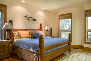 una camera da letto con letto in legno con lenzuola e cuscini blu di Skyline Drive - 108 a Elkhorn Village