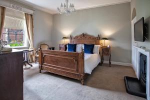 a bedroom with a large bed with blue pillows at Grays Court Hotel in York