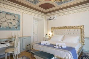 Schlafzimmer mit einem Kingsize-Bett, einem Schreibtisch und einem Stuhl in der Unterkunft Les Suite Royales in Sassari