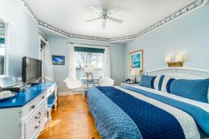 um quarto azul com uma cama e uma televisão em Goéliche hotel et appartement em Saint-Laurent-de-l'ile d'Orleans