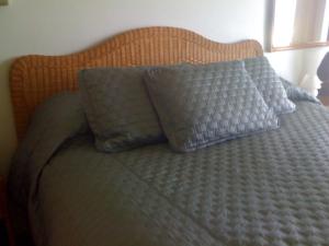 Una cama con dos almohadas azules. en Princeville Sealodge Unit D-4 en Princeville