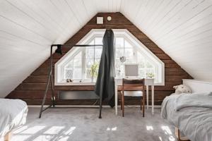 a attic bedroom with a desk and a window at Björnbacka- Chillout Oasis on the Countryside Near Stockholm in Vårsta