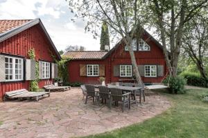 une terrasse avec une table et des chaises devant une grange rouge dans l'établissement Björnbacka- Chillout Oasis on the Countryside Near Stockholm, à Vårsta