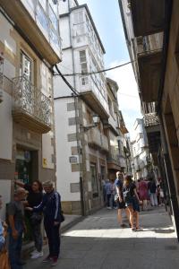 un grupo de personas de pie en una calle de la ciudad en A Casa do Calexón, en Viveiro