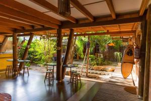 a patio with tables and chairs and a surfboard at Caza Floripa in Florianópolis