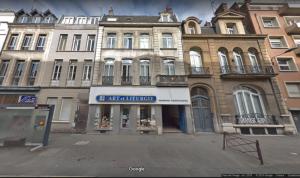 a building with a store in the middle of a street at NOCNOC - Le jardin du prefet in Lille +3 photos