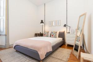 een slaapkamer met een bed met een spiegel en een dressoir bij aleixomor'Aqui in Loulé