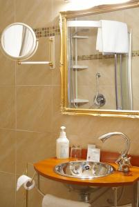La salle de bains est pourvue d'un lavabo et d'un miroir. dans l'établissement Art-Hotel Sonnenhof, à Hanau