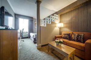 uma sala de estar com um sofá e uma mesa em Monte Carlo Inn Airport Suites em Mississauga
