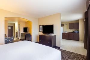 a hotel room with a bed and a flat screen tv at La Quinta by Wyndham Meridian / Boise West in Meridian
