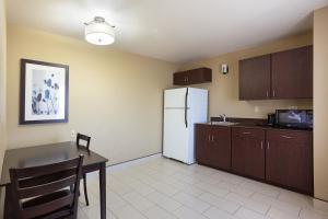 a kitchen with a table and a white refrigerator at La Quinta by Wyndham Meridian / Boise West in Meridian