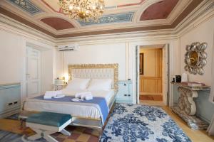 sypialnia z łóżkiem i żyrandolem w obiekcie Les Suite Royales w mieście Sassari
