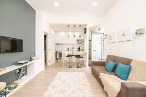 a white living room with a couch and a kitchen at Loreto Fontenary Home in Fajã de Baixo