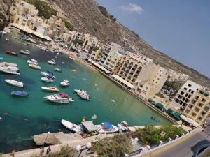 a group of boats in a body of water with buildings at Minute walk to the beach in Munxar