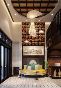 um hall de entrada com um sofá amarelo e um quadro na parede em Hanoi Center Silk Lullaby Hotel and Travel em Hanói