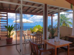 un patio con mesas y sillas y vistas al océano en Nemo Inn, en Omadhoo