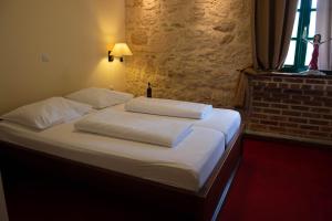 a bedroom with a bed with white sheets and pillows at Hotel Carpymore in Biograd na Moru