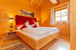 a bedroom with a bed in a wooden room at Blockhaus Ganschitter in Grossarl