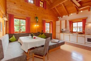 a dining room with a table and a kitchen at Blockhaus Ganschitter in Grossarl