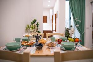 una mesa de madera con tazones de comida. en Novella Benedicta Apartments, en Florencia