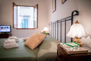 Schlafzimmer mit einem Bett und einer Lampe auf einem Tisch in der Unterkunft Novella Benedicta Apartments in Florenz