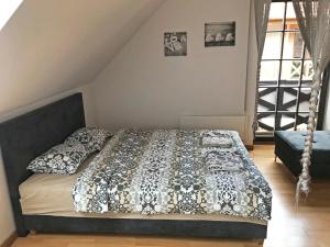 a bedroom with a bed with a black and white comforter at Apartament Sunrise in Mikołajki