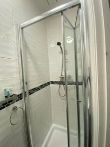 a shower with a glass door in a bathroom at Abbey Guest House in Milton Keynes