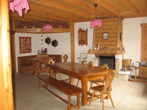 a dining room with a wooden table and a fireplace at Les Pralets Plus in La Magne